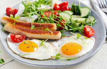 Keto breakfast. Fried eggs and chicken sausage and fresh salad.