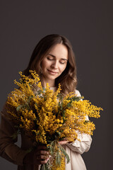 portrait of a girl with a bouquet of mimosa, spring mood, mother's day