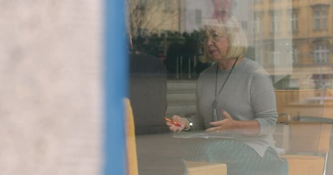 Woman psychotherapist during guidance of supervisor. Reflect on and discuss professional development. Supervision offers opportunities for peer learning and mutual support. Peek shooting from outside