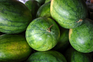 Fresh watermelons (Citrullus lanatus) on shelves in  supermarket