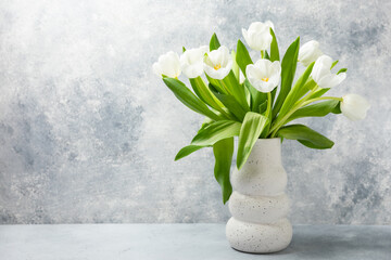 Bouquet of white tulips on a light textured background. Festive bouquet Mothers day, Valentines Day, Birthday celebration concept. Greeting card. Copy space. Place for text. - obrazy, fototapety, plakaty