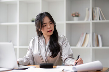 Successful Asian businesswoman dealing with business, finance, and business calculations in the office