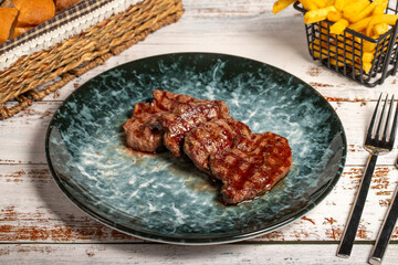 Freshly grilled beef tenderloin slices. Slices of cooked tenderloin on wood background. high...