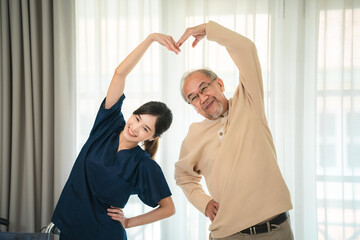 Young asian female nurse care giver helping asian senior old man in living area of nursing home...