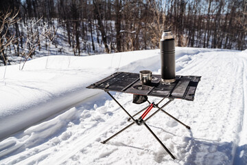 Folding Compact Camping Camping Table, Camping Utensils Stand Against Snow Background.
