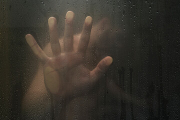 Human hands on shower glass