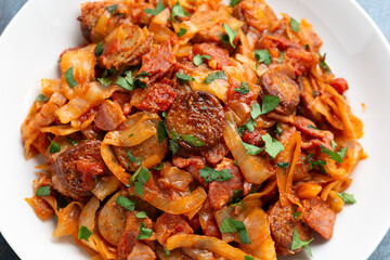 Stew cabbage with a sausage and bacon.