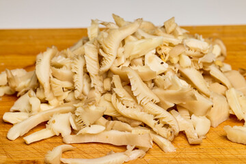 chopped mushrooms (Pleurotus) on a wooden table.