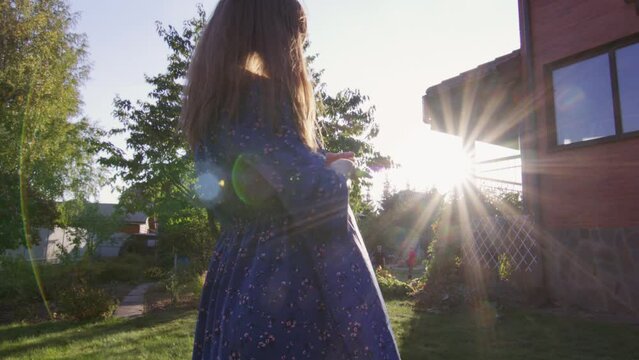 Beautiful pregnant woman enjoying fresh air at sunset rays on the backyard