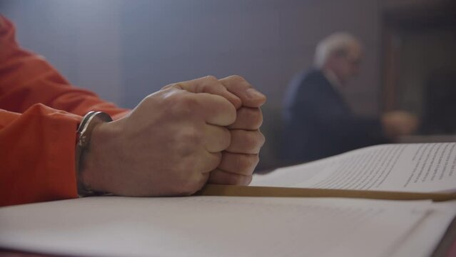 Inmate hands pounding desk in trial before judge