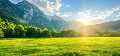 A beautiful mountain landscape with a bright sun shining on the grass