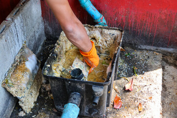 Grease traps from dirty debris being cleaned with a scoop are discarded. How to treat water with a...