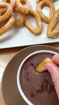 dipping a typical Spanish churro in hot chocolate
