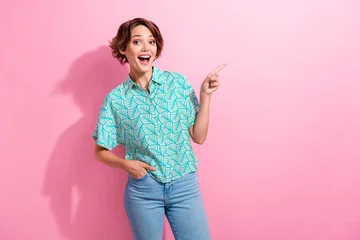 Gartenposter Portrait of shocked student lady promoter direct finger empty space wear casual shirt jeans pants isolated pink color background © deagreez