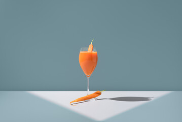 Fresh carrot juice in a glass with carrot garnish