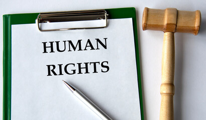 HUMAN RIGHTS - words on a white sheet on a white background and a judge's gavel