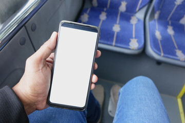 passenger sitting in a bus using his phone.