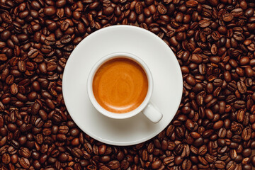 Cup of espresso coffee on coffee beans background, top view, fresh aroma coffee