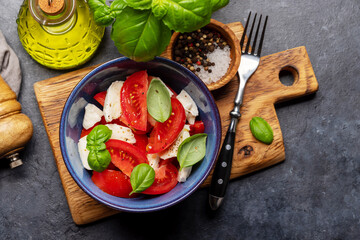 Caprese salad with ripe tomatoes, mozzarella cheese and garden basil