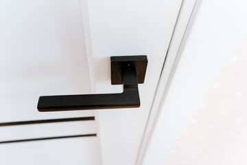 Closeup of a dark wood door handle on a white door