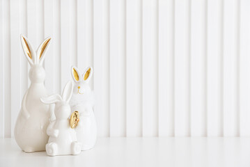 Easter rabbits figurines and eggs on white background. Easter celebration concept. Copy space....