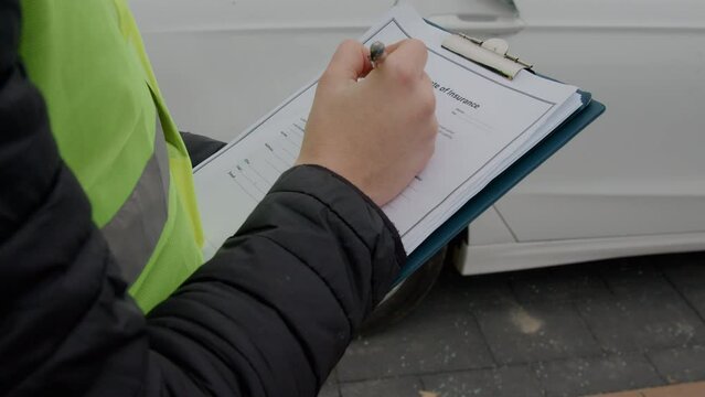 scene is an inspector meticulously documenting details on an auto insurance document, exemplifying the concept and importance of car insurance