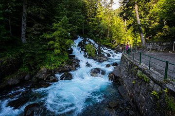 Fototapeta premium Summer and young girl in Uelhs Deth Joeu waterfall, Val D Aran, Spain