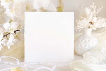 Obraz na płótnie Canvas Card near white orchid flowers and decor close up, pastel romantic wedding mockup