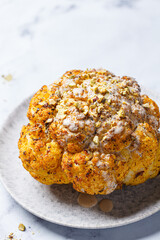 Spicy baked cauliflower with tahini dressing and pistachios. Vegan recipe.