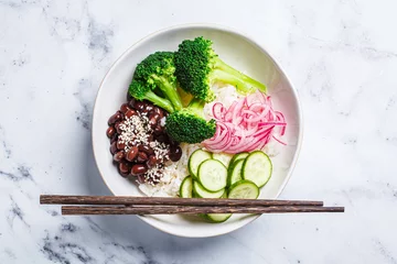 Fotobehang Vegan poke. Bowl with rice, broccoli, cucumber, beans and pickled red onion, white background. © vaaseenaa