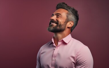 Fototapeta premium A man with a beard and a pink shirt is smiling