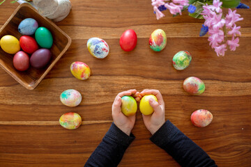 Little blond toddler boy child coloring easter eggs at home, Czech Republic tradition