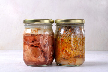 Different canned stewed meat. Two glass jars with canned pork and buckwheat, prepared preserved meal