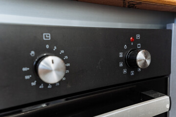 Obraz premium Kitchen appliance Close up of a black oven with silver knobs