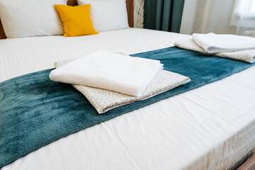 Rectangle wood bed with blue blanket, white linens, and pillows for comfort