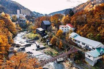 Sapporo, Hokkaido, Japan - November 2023 : Autumn scenery of Jozankei Onsen Resort, a famous hot spring destination with the hotels and traditional Ryokan surrounded by fall colors. - obrazy, fototapety, plakaty