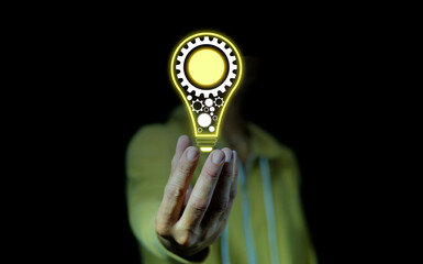 hand of a man with a light bulb And there is a gear icon . The idea of ​​inspiration from online technology. innovation idea concept