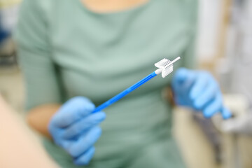 Gynecologist examines a patient takes a smear from a woman cervix. Close up view of doctor hands with gynecological cytobrush. Diagnosis of female viral and infection diseases
