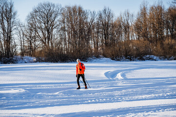 Skier skiing in the snow in the park, healthy outdoor recreation outside the city in winter.