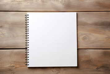 A closed spiral notebook with a black or dark blue cover rests on a wooden table. Space for text.