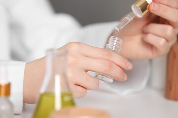 Dermatologist testing essential oil indoors, selective focus