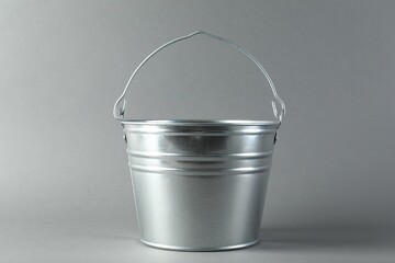 One shiny metal bucket on light grey background - obrazy, fototapety, plakaty