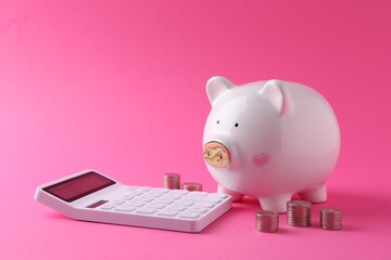 Financial savings. Piggy bank, coins and calculator on pink background