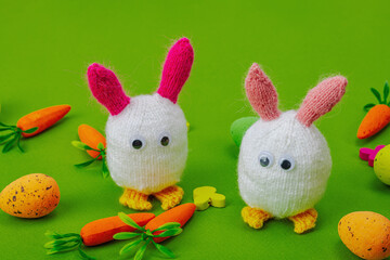 Handmade Easter concept. Knitted bunnies with traditional decoration. Festive symbols, greeting card