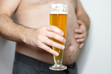fat man with a mug of beer close-up. Beer belly, overweight. Man with mug of beer, close up. Alcoholism, unhealthy lifestyle