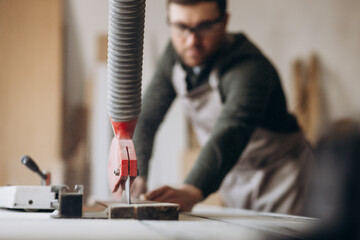 Carpenter working with wood and saw in the manufacturing industry