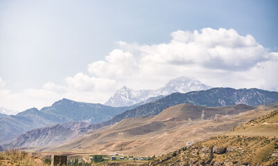 Fototapeta premium Panorama of mountain ranges and peaks of the Fan Mountains with glaciers, rocks and vegetation in Tajikistan on a summer sunny day