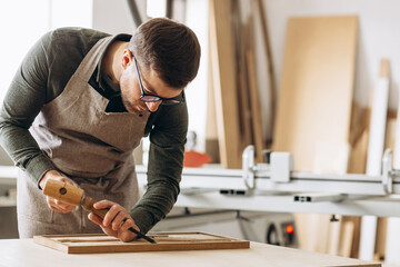 Carpenter making wood carving at the wood factory