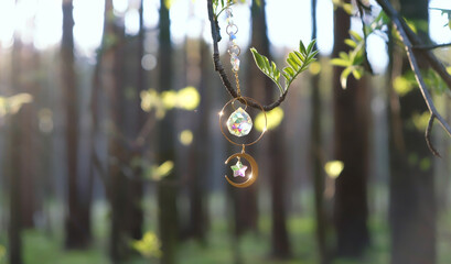 Crystal sun catcher prism on tree branch, abstract sunny forest background. Magic crystal Ritual, Witchcraft, esoteric practice for harmony, calm soul, productive the mind. Feng Shui, reiki therapy - obrazy, fototapety, plakaty