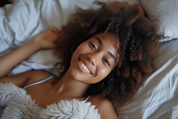 a beautiful and happy young African woman is relaxing in bed